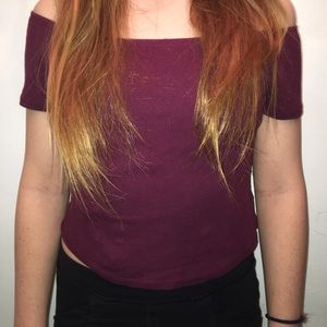 A cropped off shoulder burgundy ish shirt.