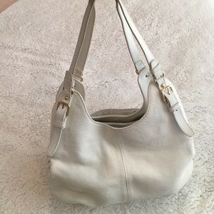 White leather hobo style purse with gold accents.