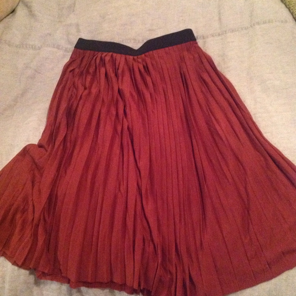 Maroon pleated knee length skirt.