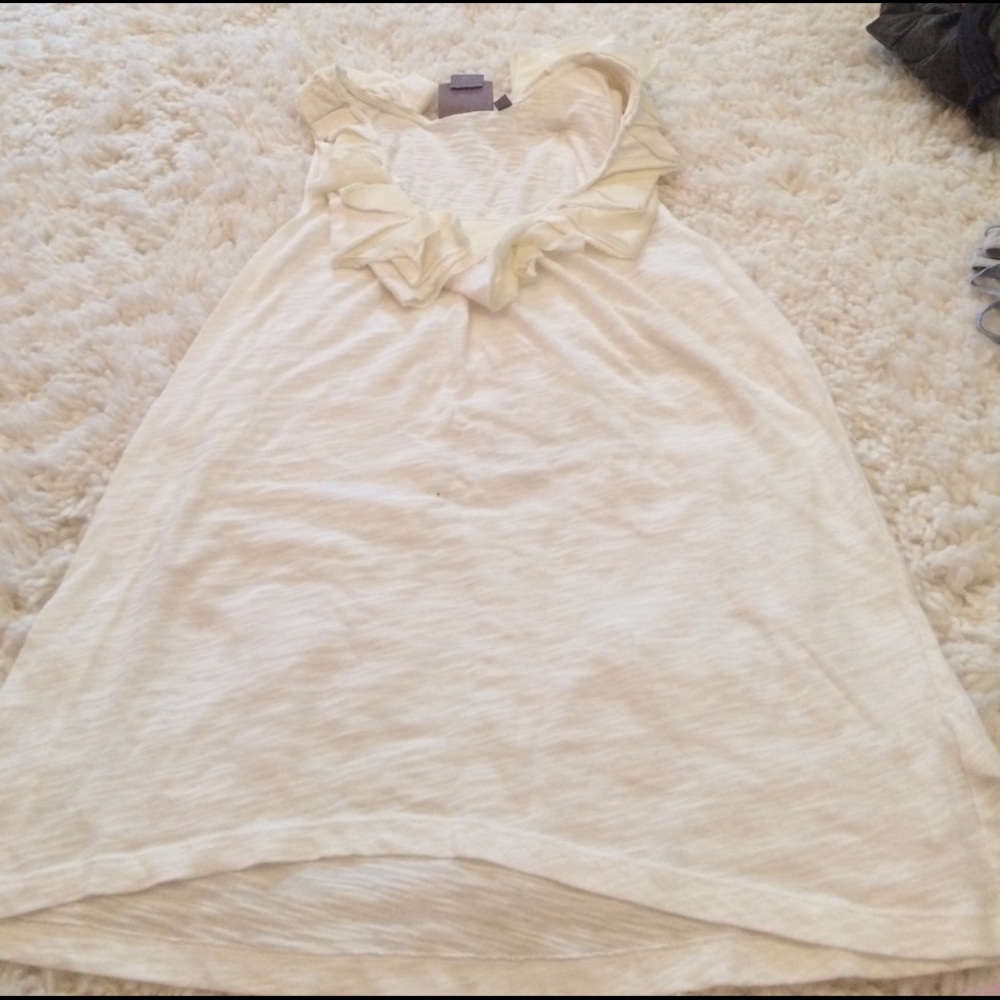 White tank with ruffles around the neck