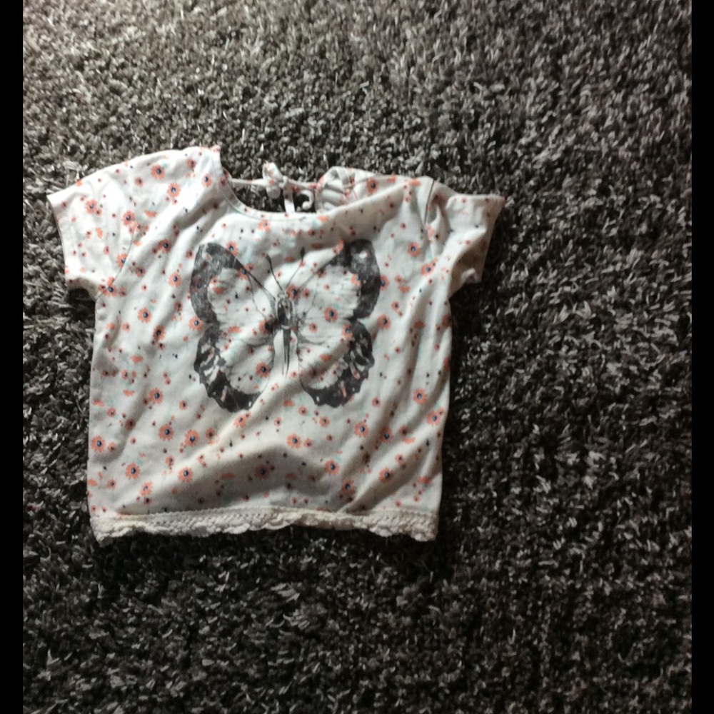 White blouse with salmon colored flowers on it.