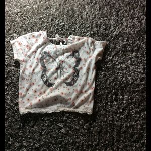 White blouse with salmon colored flowers on it.