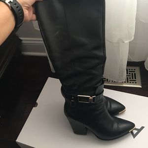 Black knee high boots with a block heel.