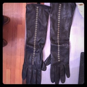Elbow length leather gloves with grommets.