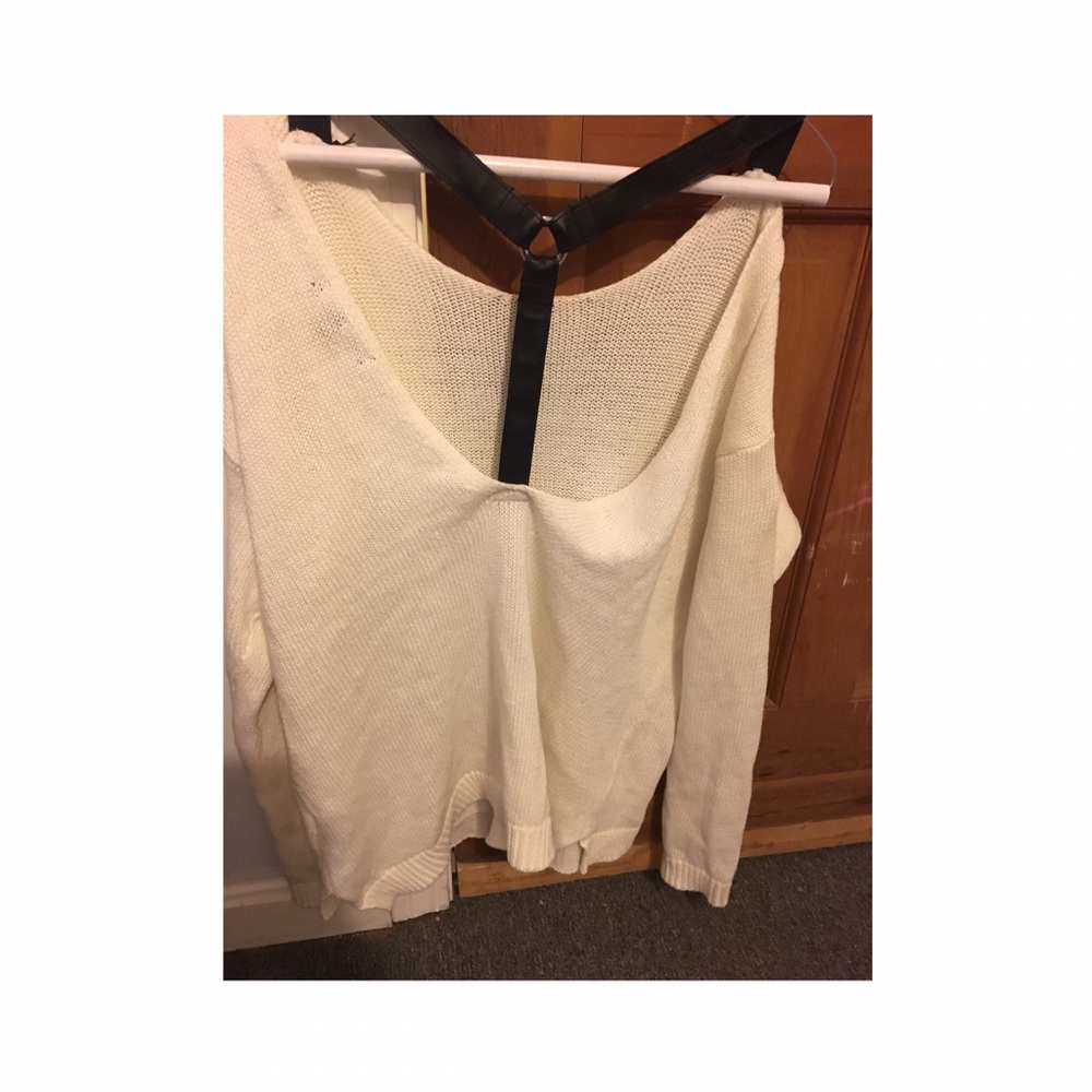 White sweater with open back and black straps