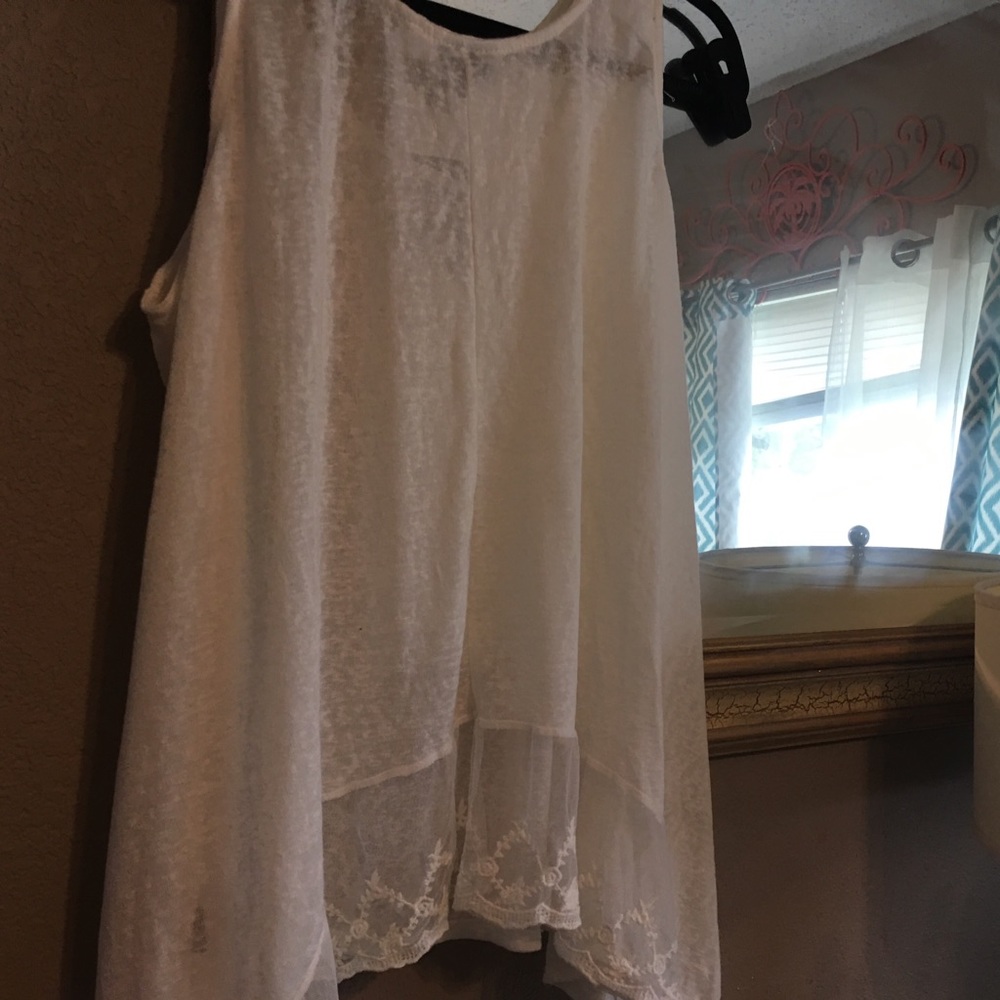 Very light beige top with lace on back bottom .