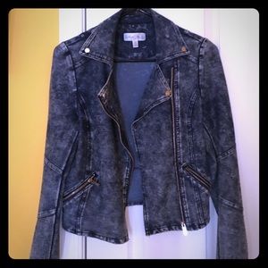Dark blue jean jacket with gold zippers.