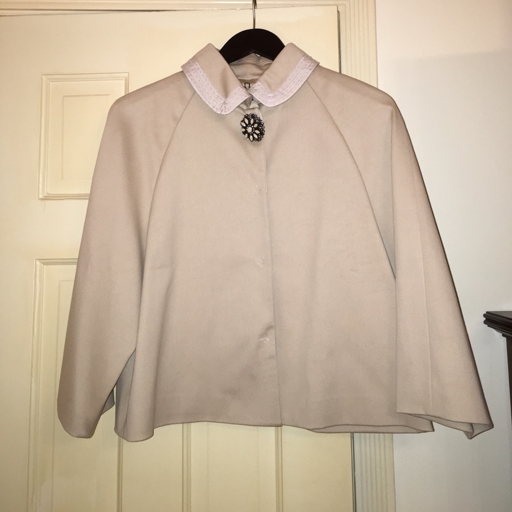 Khaki cotton evening jacket. Jeweled pin at neck