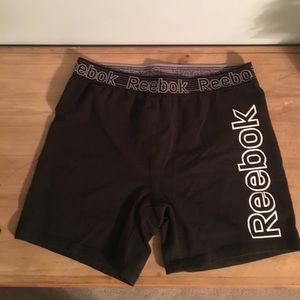 Black Reebok shorts with white lettering