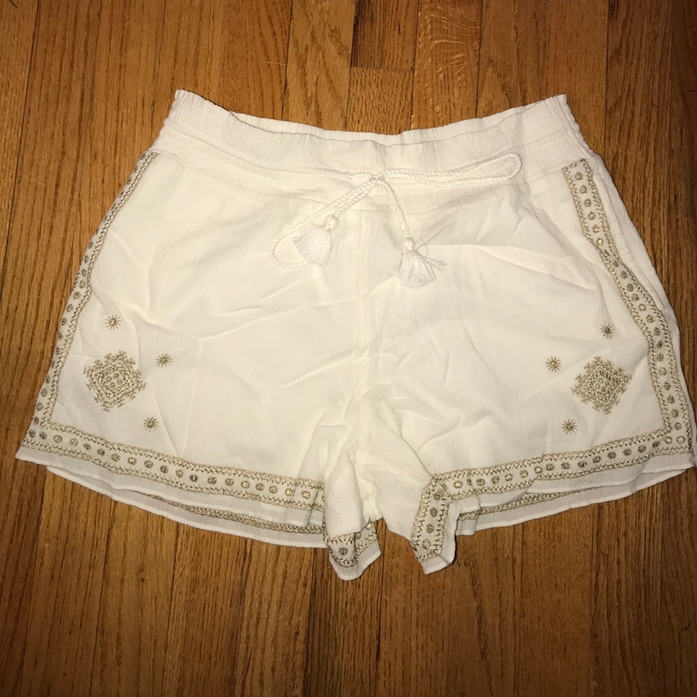 White shorts with gold embroidered aztec patterns