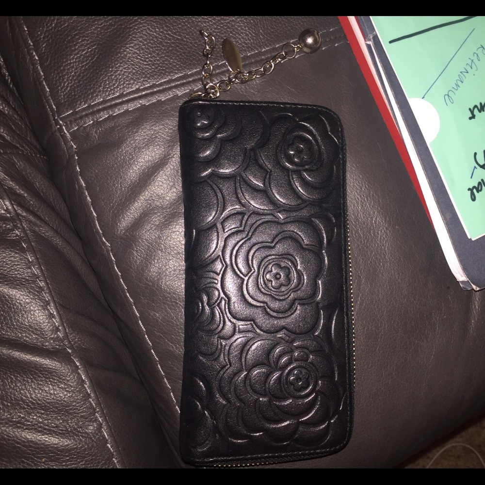 Black zip-up wallet with flower design.