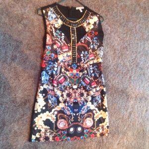 Colorful dress with ornate necklace in gold.