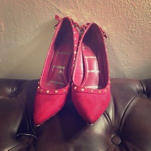 Red suede pumps with gold studded accents