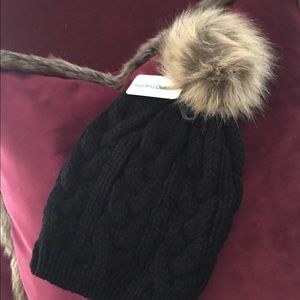 Cable knit beanie with fur pom pom.