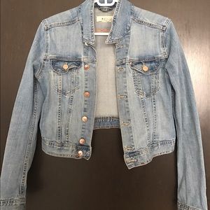 A light washed denim jacket with rose gold buttons