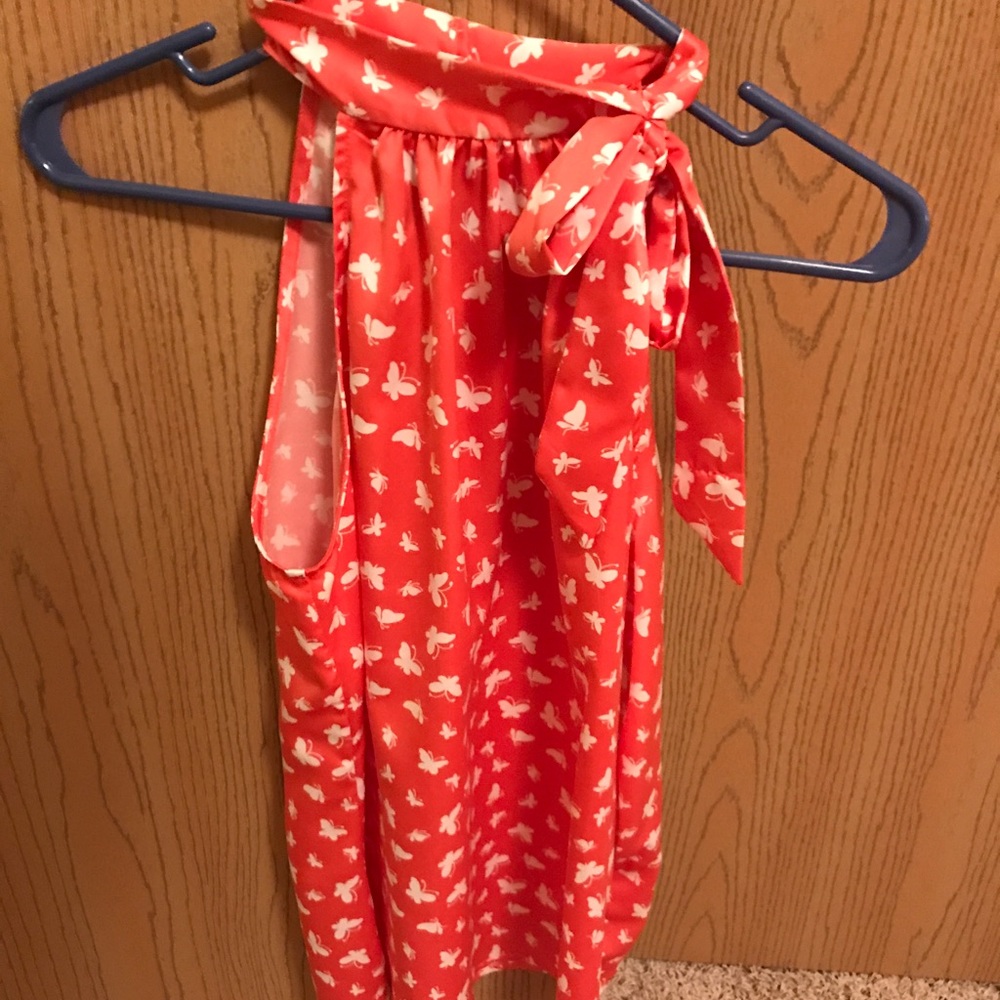 Bright coral sleeveless top w/white butterflies.