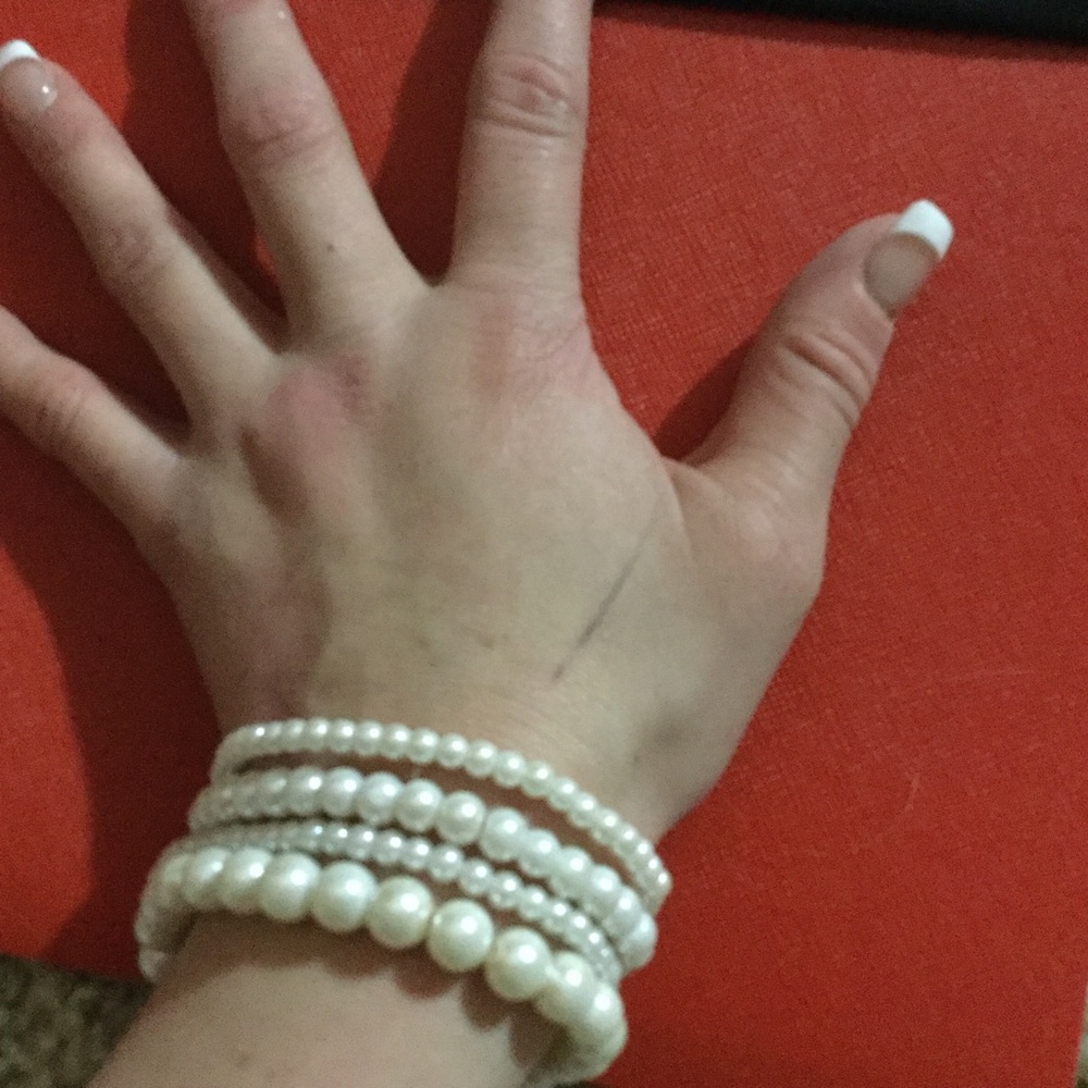 Different sized white pearl like beaded bracelets
