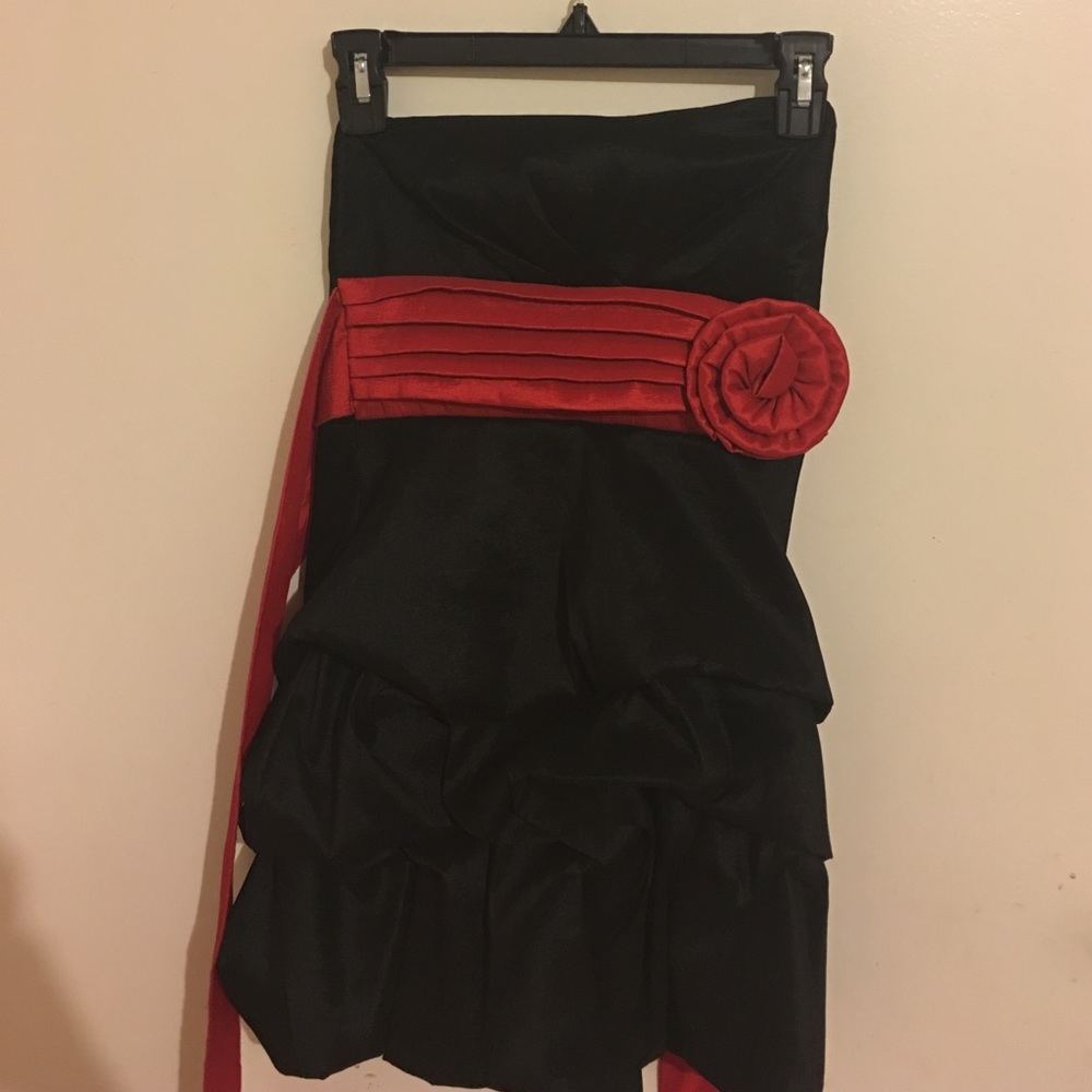 Strapless black ruffle dress with red flower ban