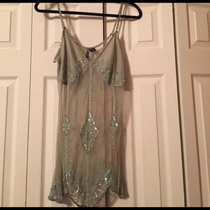 A beaded see through shirt with beaded straps.