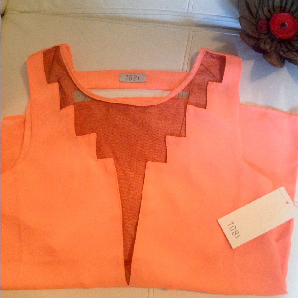 Coral sleeveless blouse with black mesh detail.