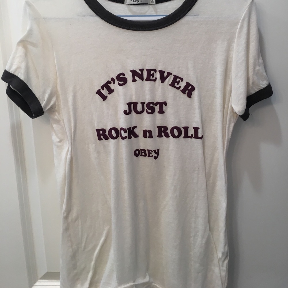 A cream t-shirt with gray lining on the sleeves.