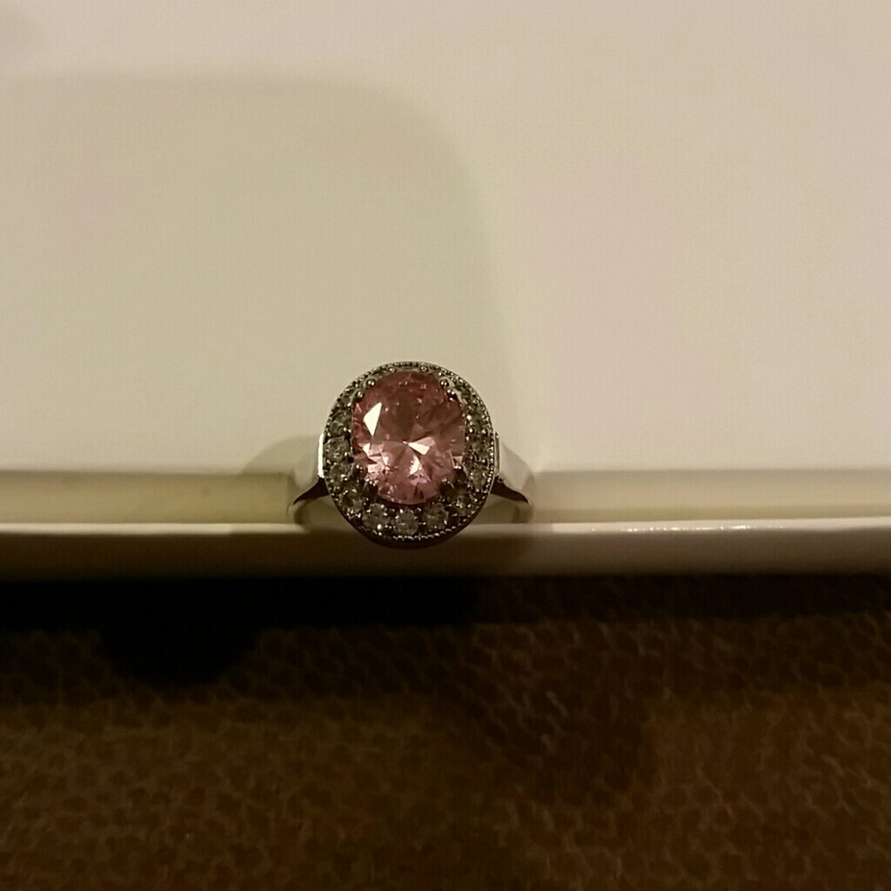 Large pink oval surrounded by diamonds silver band