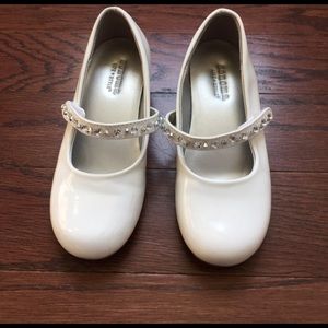 Gently used girl's white dress shoes.