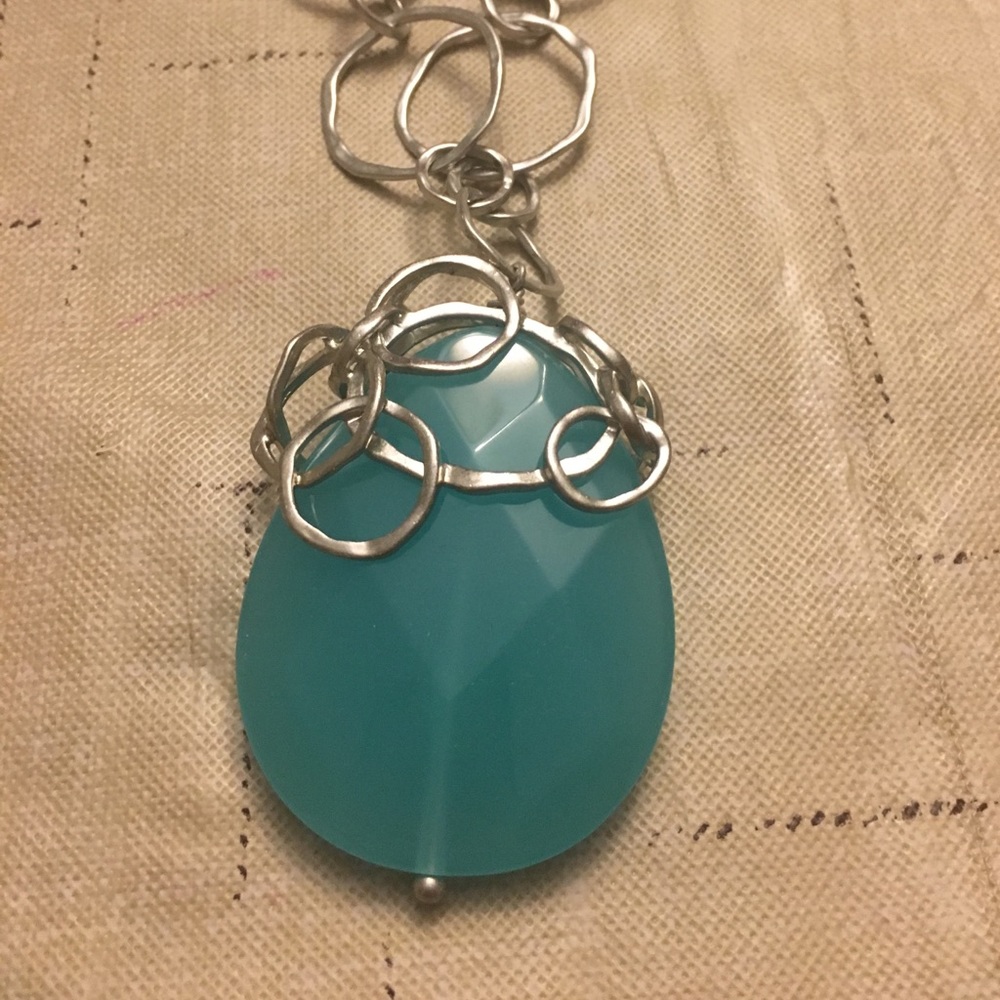 Long silver necklace with blue colored gem