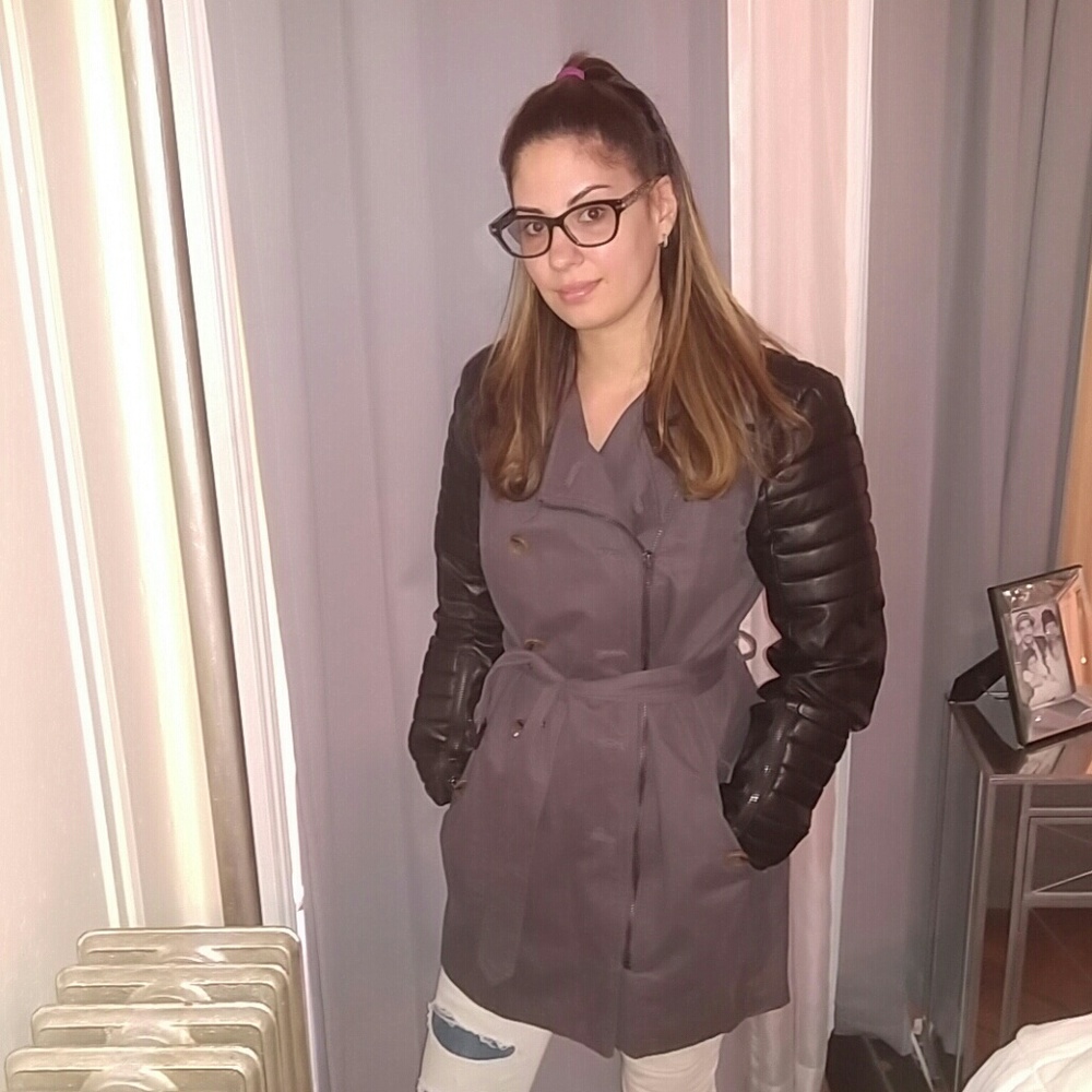 Military trench with faux leather sleeves.