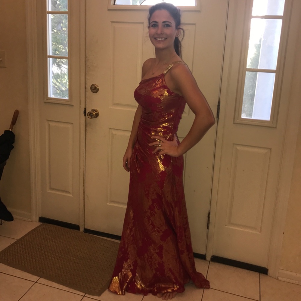 A red and gold one shoulder full length gown.