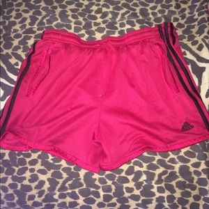 Hot pink adidas shorts with black stripes