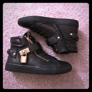High top black sneakers with gold hardware
