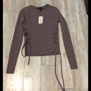 Long sleeved tan shirt with ties on the sides