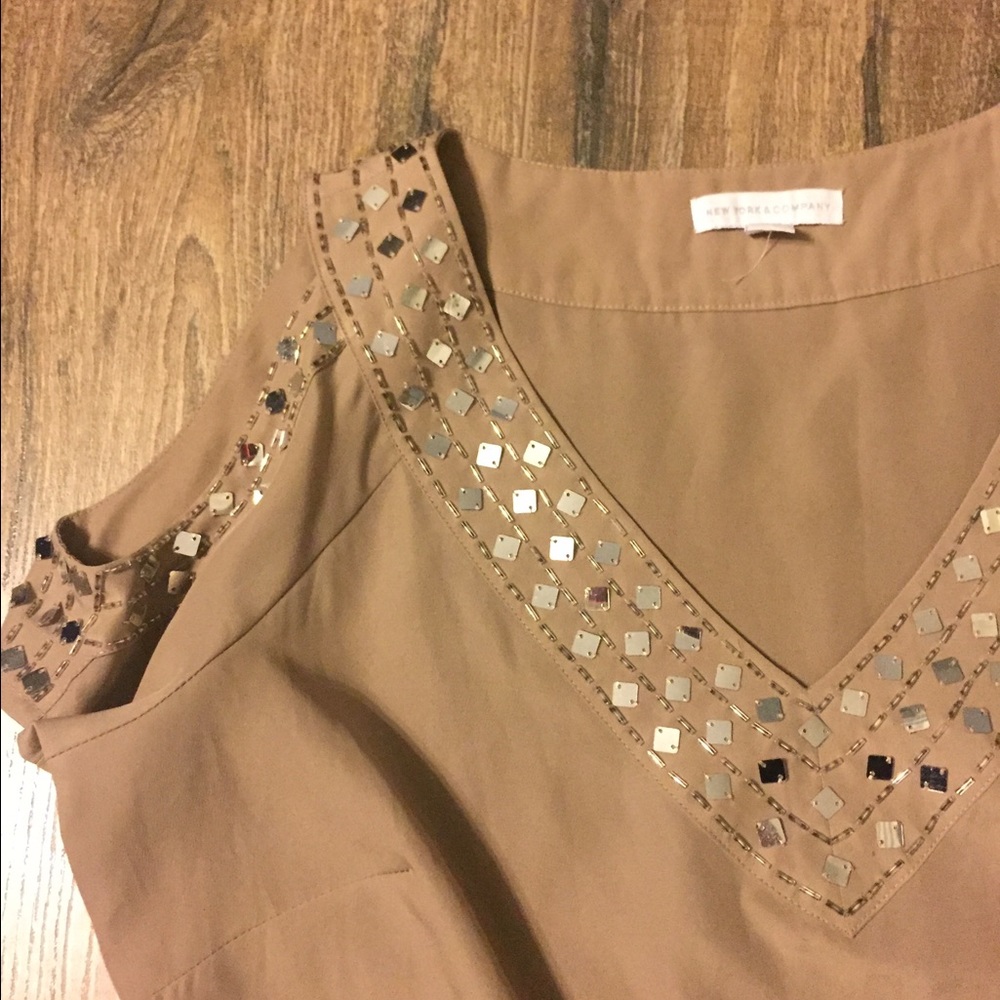 Open shoulder tan and gold shirt.