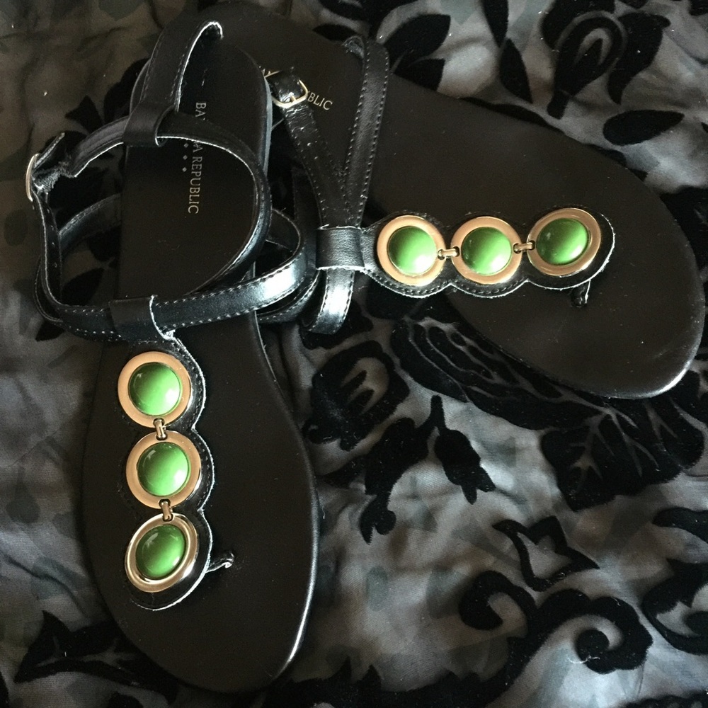 Black sandal with green gemstone