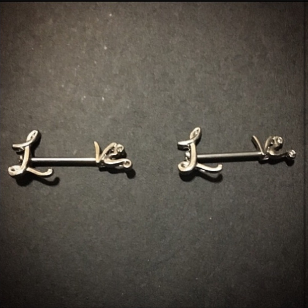 Nipple rings that spell "love"