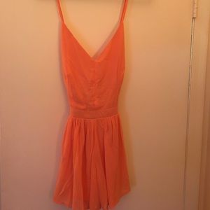 Orange cris-crossed back romper. NWOT