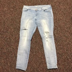 Washed out jeans with holes in thighs