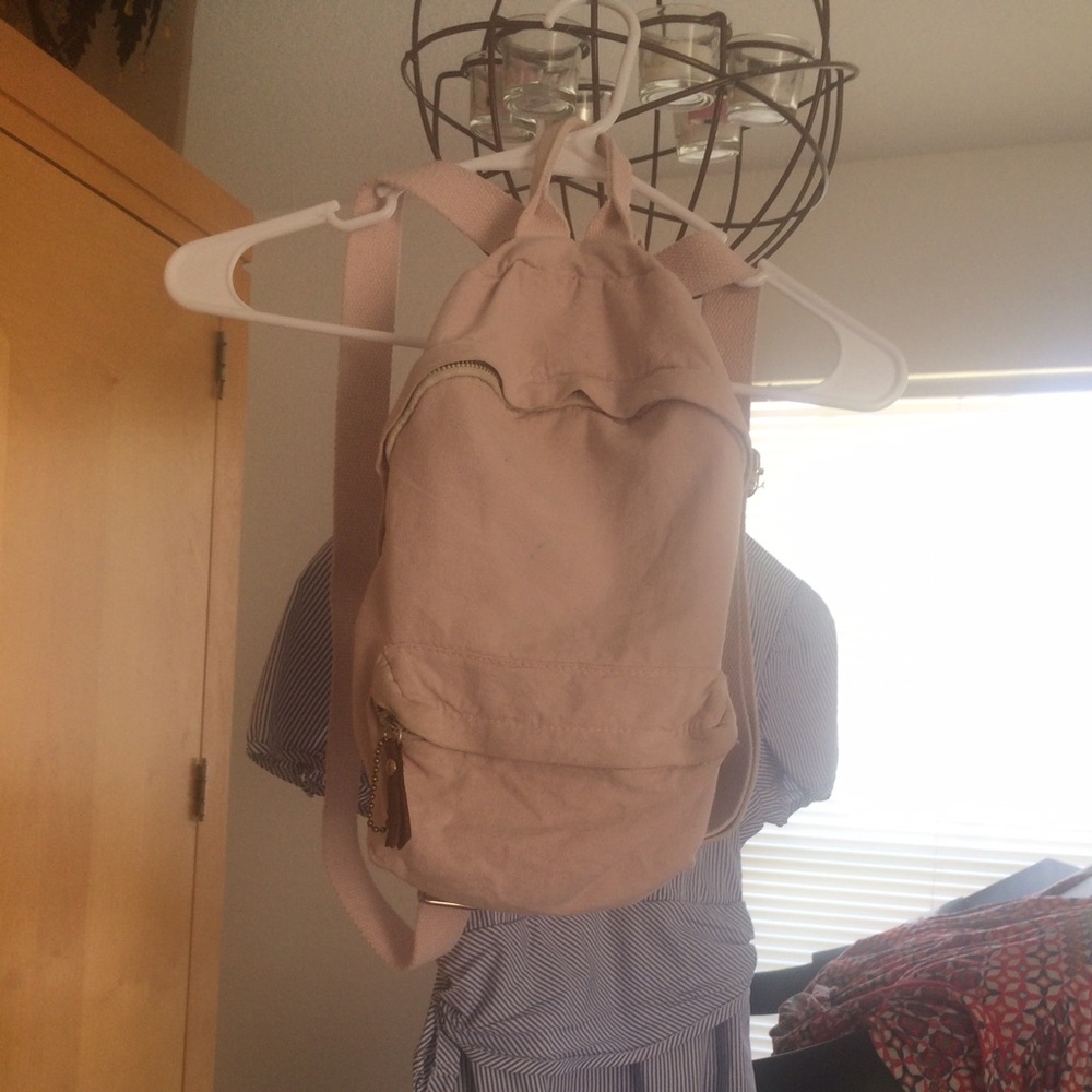 Pink mini cloth backpack with brown detail .