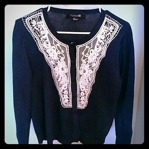 Navy blue cardigan with cream lace overlay.