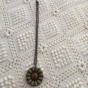 Aged bronze necklace with a brown center.