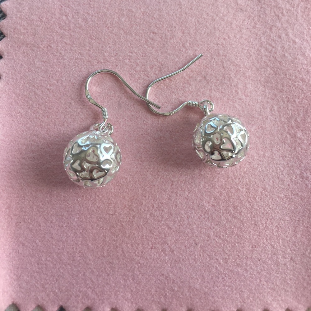 Silver dangle ball earrings.