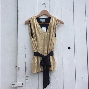Sleeveless gold top with black ribbon belt