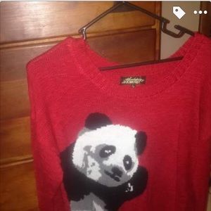 Red sweater with a panda bear on it.