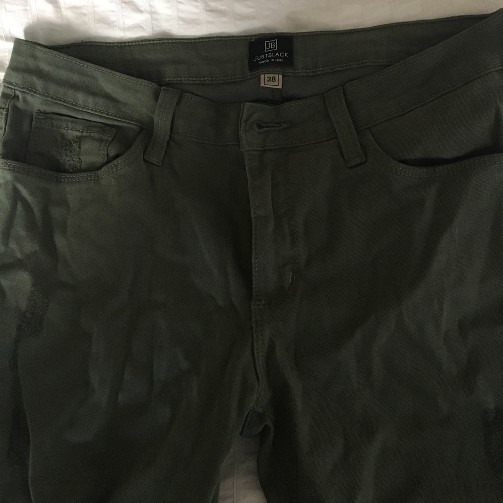 Green jeans with rip in right knee