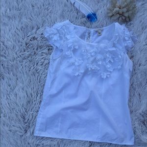 J Crew white ruffle blouse with fabric flowers.