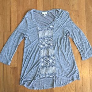 Grey blouse with white embroidering.