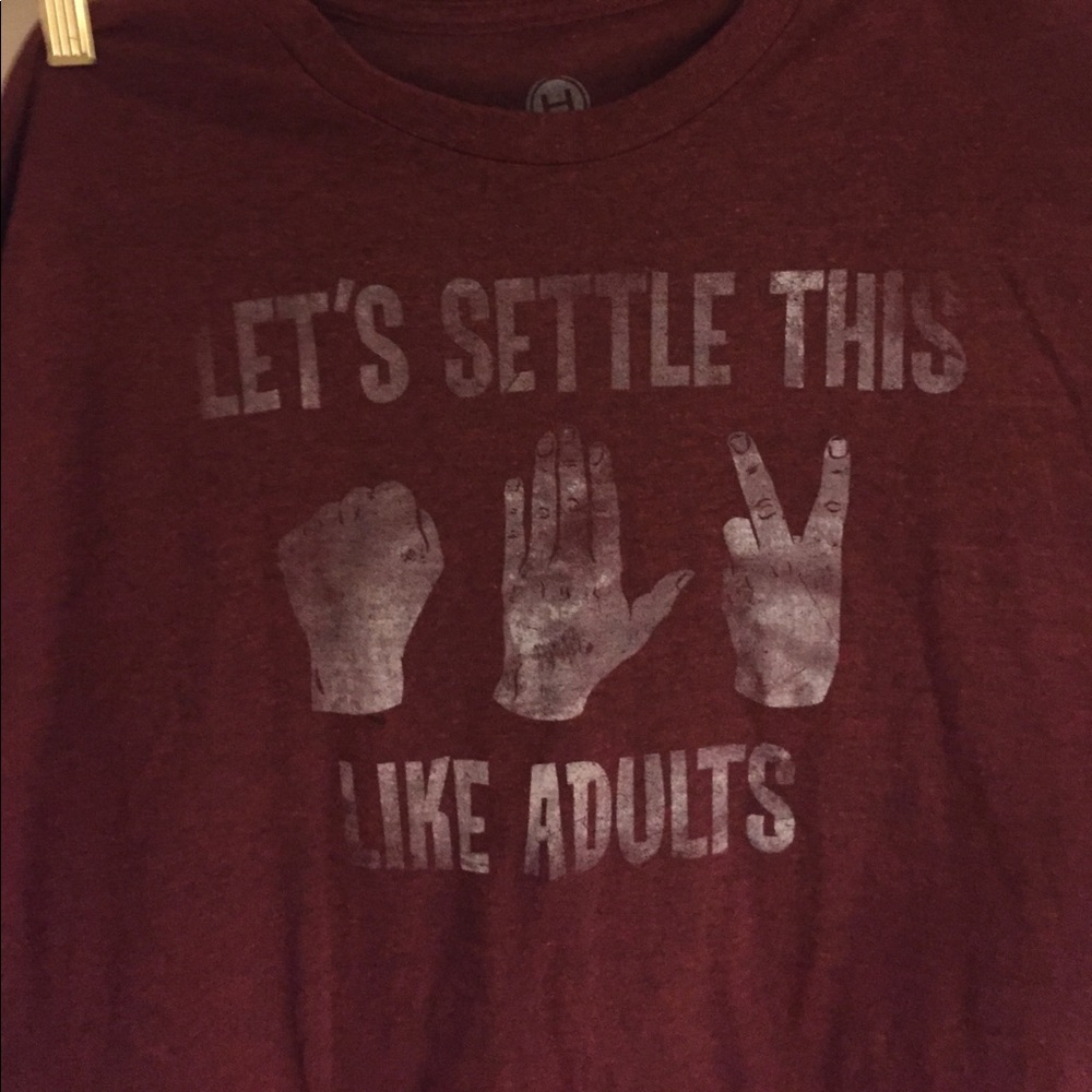 Red Tshirt says "lets settle this like adults"