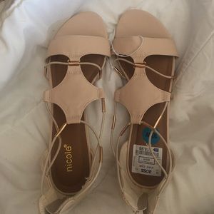 Creme wedge sandal with gold detailing.