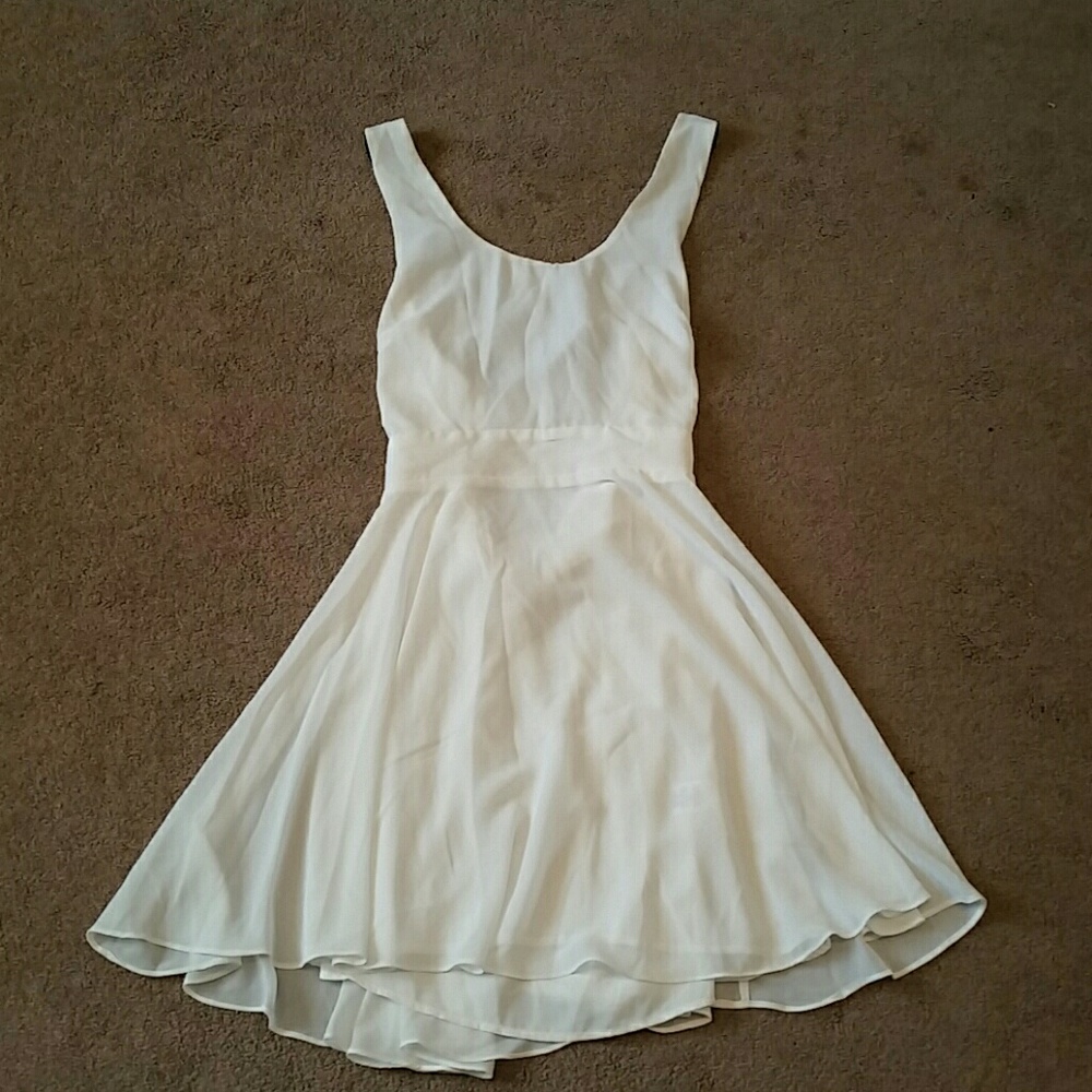 Short, white dress with black straps
